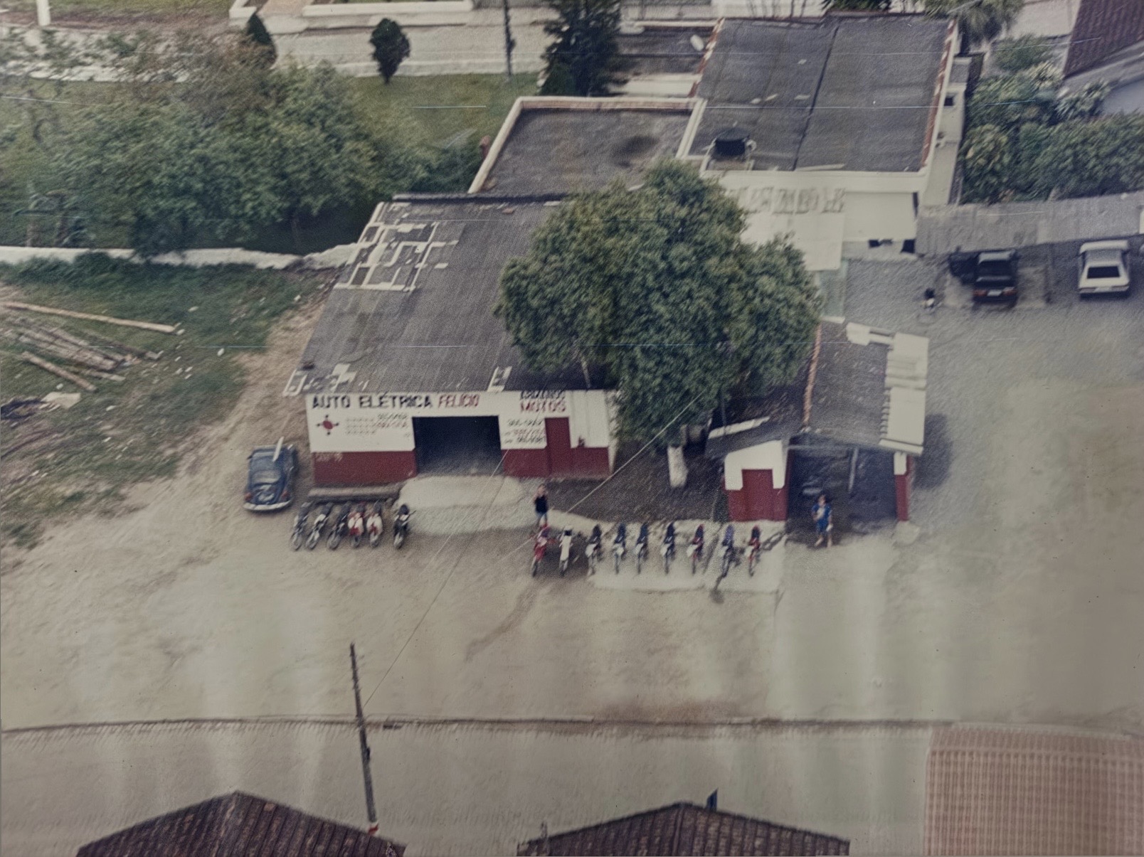 Fotografia histórica aérea da loja Armando Motos, com motocicletas em frente à fachada